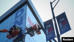 Los trabajadores cuelgan carteles en el exterior del United Center mientras preparan el sitio para la Convención Nacional Demócrata en Chicago, Illinois, EEUU, el 13 de agosto de 2024.