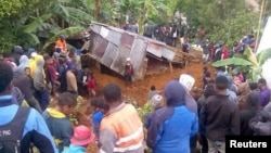 Locals surround a house that was covered by a landslide in the town of Mendi after an earthquake struck Papua New Guinea's Southern Highlands in this image taken Feb. 27, 2018, obtained from social media.