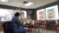 A woman eats in a fast food restaurant as a television shows live coverage of U.S. President Donald Trump's U.S. Senate impeachment trial three days before the Iowa caucus in Des Moines, Iowa, Jan. 31, 2020.