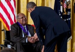 President Barack Obama awards Ernest Gaines the 2012 National Medal of Arts for his contributions as an author and teacher, July 10, 2013, during a ceremony in the East Room of White House in Washington.