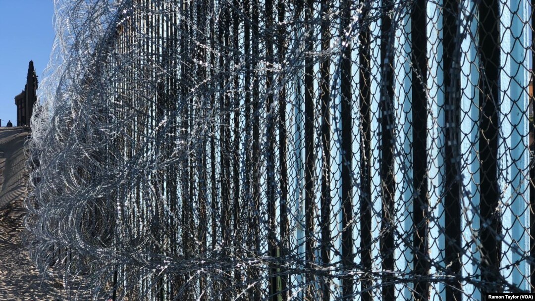 Border wall reinforced with barbed wire to prevent migrants from illegally entering into the United States. 