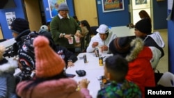 Un trabajador entrega comida a migrantes que no fueron aceptados en su cita con la Oficina de Aduanas y Protección Fronteriza (CBP) de Estados Unidos, en Ciudad Juárez, México, el 21 de enero de 2025.