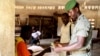 A Togolese soldier has his identity checked before casting his ballot during the early voting for the country's parliamentary elections, at the RIT camp in Lome, July 22, 2013.