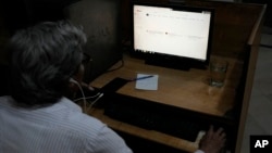 FILE - A Pakistani waits to open an internet page on a desktop in Lahore, Pakistan, Aug. 19, 2024. Pakistan's top cleric has declared that virtual private networks, or VPNs, are unlawful.