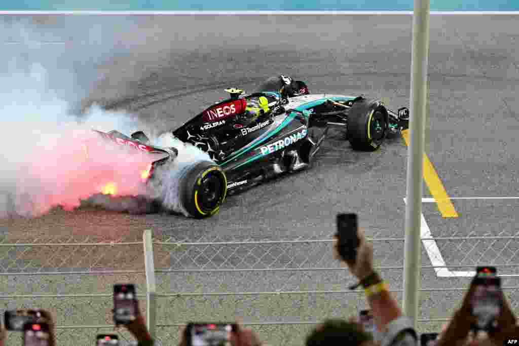 Mercedes&#39; British driver Lewis Hamilton performs a burn out after the Abu Dhabi Formula One Grand Prix at the Yas Marina Circuit in Abu Dhabi, United Arab Emirates.