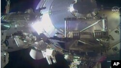File - In this image taken from NASA video, NASA astronauts Victor Glover and Mike Hopkins make routine maintenance on the International Space Station’s European lab on Jan. 27, 2021.