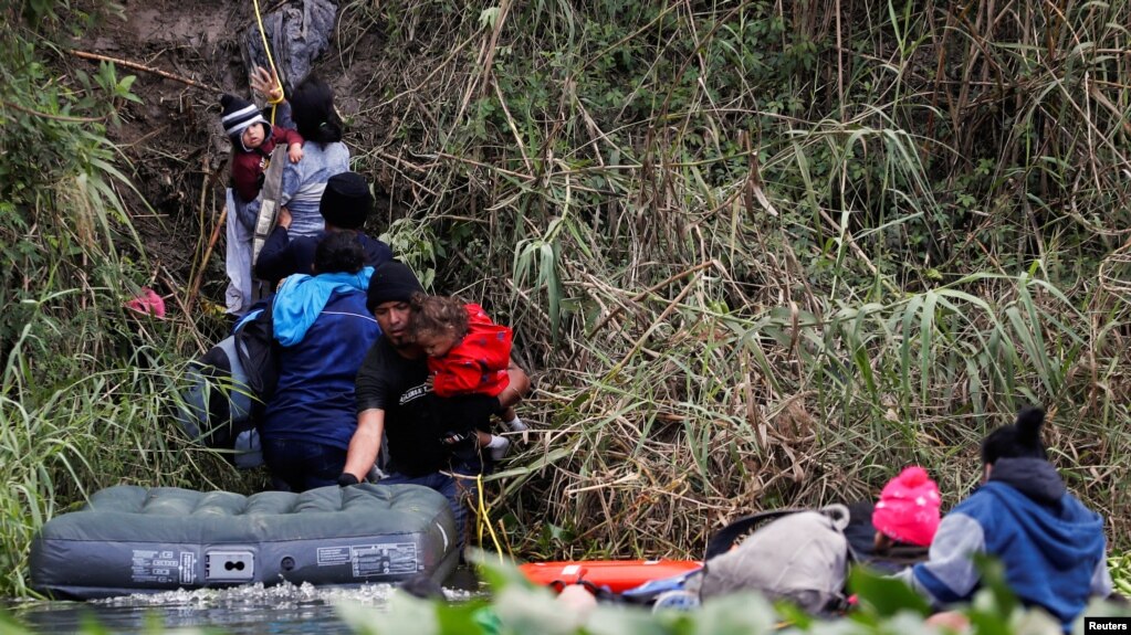Migrantes que buscan asilo en Estados Unidos cruzan el río Bravo, en la frontera entre Estados Unidos y México, en Matamoros, México, el 21 de diciembre de 2022.