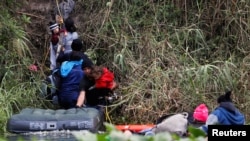 Migrantes que buscan asilo en Estados Unidos cruzan el río Bravo, la frontera entre EEUU y México, después de que la Corte Suprema de Estados Unidos dijera que el Título 42 debería mantenerse por ahora, en Matamoros, México, 21 de diciembre de 2022.