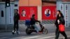 FILE PHOTO: People cross a street in front of posters depicting late Chairman Mao Zedong (R) and China's President Xi Jinping in Shanghai, China, March 1, 2016. 