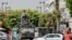 Tunisians walk past a military armored personnel carrier at Habib Bourguiba Avenue July 30, 2021. 