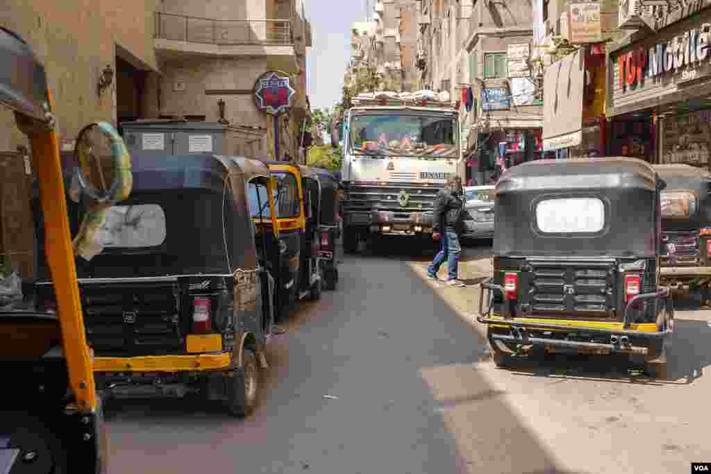 Toktoks are waiting for passengers to drive them into the corridors of suburbs- usually cause a traffic jam in front of Hadayek El-Maadi metro station in Cairo. (H. Elrasam/VOA)