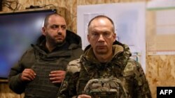 This handout photograph released on February 25, 2024 by Press service of Ukrainian Armed Forces, shows Commander-in-Chief of the Armed Forces of Ukraine Oleksandr Syrsky (R) and Ukraine's Defence Minister Rustem Umerov (L) visiting the frontline position