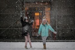 Niños juegan en la nieve frente al edificio de la Bolsa de Valores de Nueva York el 18 de febrero de 2021.