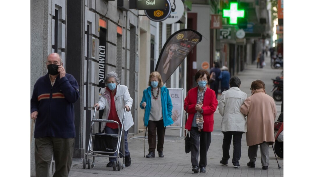 Para pejalan kaki mengenakan masker wajah di Madrid, Spanyol, 13 Mei 2020.