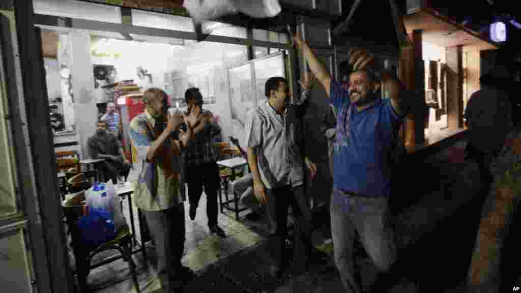 Egyptians celebrate at a tea house in Cairo after Defense Minister General Abdel-Fattah el-Sissi's televised statement, July 3, 2013.