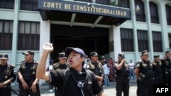 En la foto de archivo, un estudiante de magisterio protesta frente a la Corte de Constitucionalidad que es protegida por la policía, mientras participa de una marcha contra la privatización de la educación. Guatemala el 26 de abril de 2007.. 