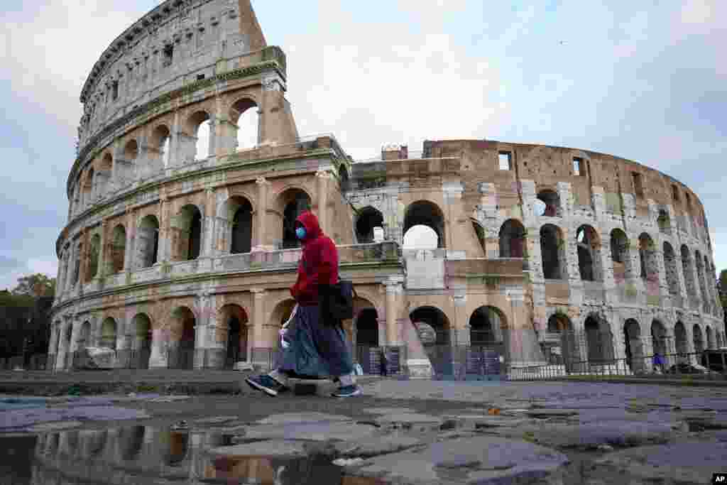 عبور یک عابر از مقابل کولوسئوم یا تماشاخانه مشهور شهر رم در ایتالیا. ایتالیا روزانه بیش از سی هزار مورد جدید کرونا را ثبت می‌کند. 