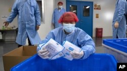 지난 4월 중국 후베이성 우한의 마스크 공장에서 직원이 완제품을 정리하고 있다. (자료사진)