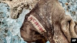 A sock embroidered with "A.C. Irvine" is discovered connected  the Central Rongbuk Glacier beneath  the North Face of Mount Everest, Oct. 11, 2024. (Jimmy Chin/National Geographic via AP)