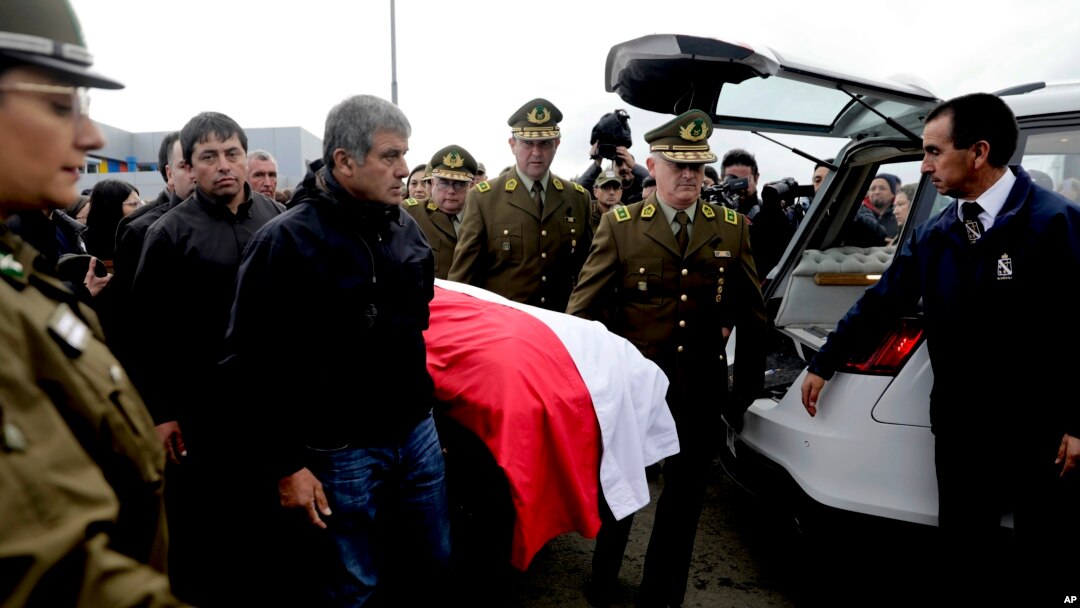 Familiares y amigos acompañan los restos del policía asesinado Carlos Cisterna, en un cementerio en Lebu, Chile, el martes 30 de abril de 2024, luego que atacantes armados emboscaron y mataron a tres agentes de la ley, en el sur de Chile antes de prender fuego a su automóvil.