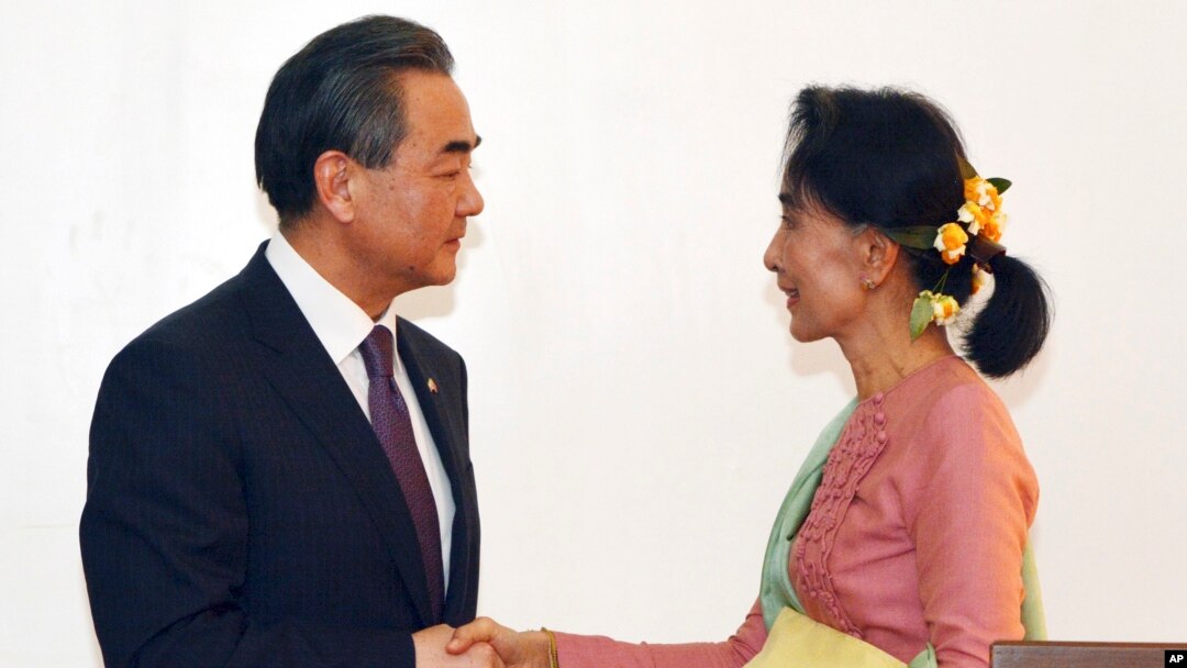 缅甸民主联盟领导人、缅甸新任外交部长昂山素季与到访的中国外长王毅握手(2016年4月5日)
