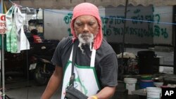 A red shirt protester sets up a grill at a food stall in the protest zone in Bangkok, 06 May 2010