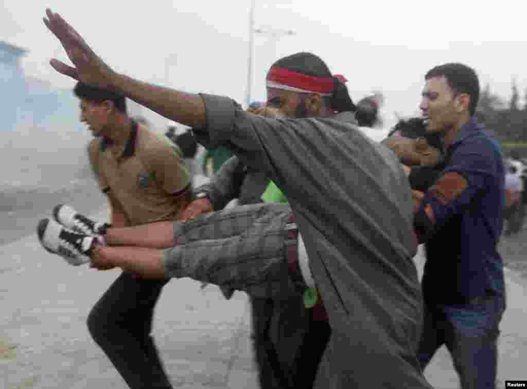 Supporters of deposed Egyptian President Mohamed Morsi carry a protester injured during clashes with police and Morsi opponents, in the Nasr City area of Cairo July 27, 2013.