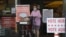 A shopper wearing a mask for protection against COVID-19 leaves a grocery store that is also serving as an early polling site, July 9, 2020, in Austin, Texas.
