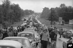 FILE - Hundreds of rock music fans jam a highway leading from Bethel, N.Y., as they try to leave the Woodstock Music and Art Festival, Aug. 16, 1969.