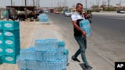 FILE - A man buys drinking water in Basra, southeast of Baghdad, Iraq, July, 21, 2019. 