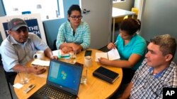 FILE - Juan Lopez, left, sits with fellow Honduran environmental activists during an interview in Washington, D.C. Oct. 3, 2019.