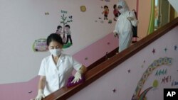 FILE - In this June 30, 2021, photo, staff of the Pyongyang Primary School No. 4 clean stairwells in Pyongyang, North Korea. 