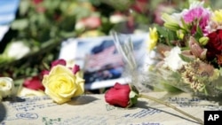 Family members of the victims of 9/11 write notes and leave flowers while they gather around the Ground Zero reflecting pool at the site where the twin towers once stood on the ninth anniversary of the terrorist attacks on the World Trade Center, in New Y