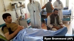 In this undated photo provided by Ryan Brummond, Mohammad Khalid Wardak, left, receives medical attention at a hospital in Afghanistan.