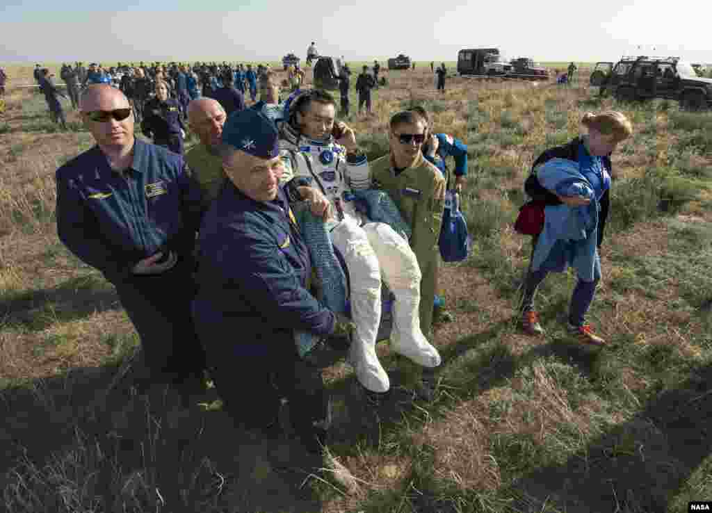 Expedition 39 Commander Koichi Wakata of the Japan Aerospace Exploration Agency (JAXA) is carried in a chair to a medical tent just minutes after he and Soyuz Commander Mikhail Tyurin of Roscosmos, and Flight Engineer Rick Mastracchio of NASA, landed in their Soyuz TMA-11M spacecraft near the town of Zhezkazgan, Kazakhstan.