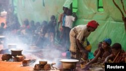 FILE: Refugees from Burundi who fled the ongoing violence and political tension prepare meals at the Nyarugusu refugee camp in western Tanzania, on May 28, 2015.