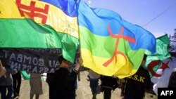 FILE - Demonstrators wave Berber flags in Agouni Arouss, Algeria, April 18, 2002. Suspected members of MAK, a group seeking independence for the Berber-speaking Kabylie region, were arrested after attacks in Algeria, police said Sept. 6, 2021.