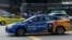 Taksi Comfort Delgro dengan iklan menawarkan layanan di aplikasi Uber melintasi jalan di Singapura pada 26 Maret 2018. (Foto: AFP)