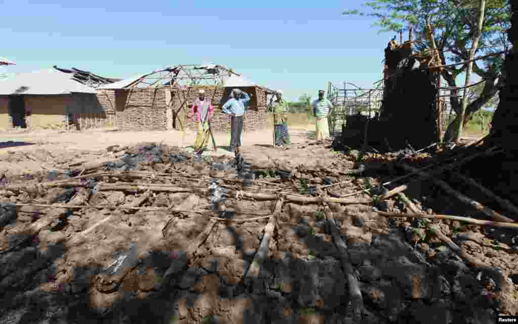 Residents look at a house that was destroyed when their village was attacked, Nduru village in the Tana Delta region of Kenya, January 9, 2013.