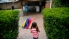 FILE - A girl waves the Venezuelan flag during a visit to bid goodbye in her grandparents' house, before her move to the U.S. after winning the green card lottery, in Valencia, April 6, 2014. 