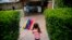 FILE - A girl waves the Venezuelan flag during a visit to bid goodbye in her grandparents' house, before her move to the U.S. after winning the green card lottery, in Valencia, April 6, 2014. 