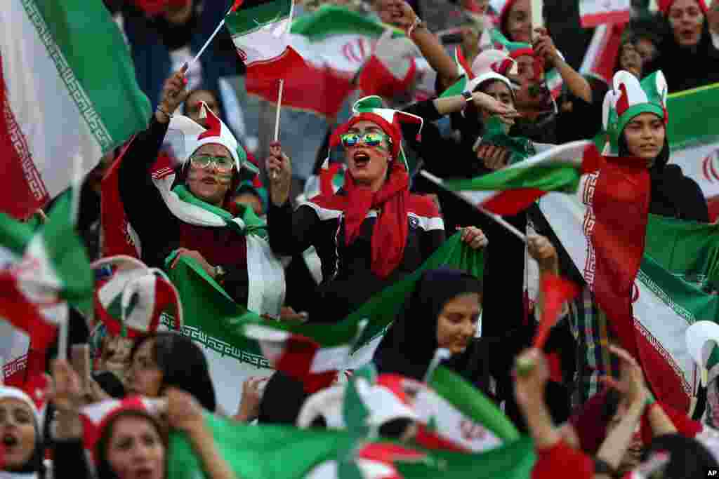 Iranian women cheer during a soccer match between their national team and Cambodia in the 2022 World Cup qualifier at the Azadi (Freedom) Stadium in Tehran. Iranian women were freely allowed into the stadium for the first time in decades.