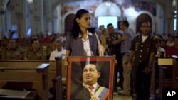 Žena sa slikom venecuelanskog predsednika Uga Čaveza donosi njegovu sliku na misu u jednoj crkvi u Havani, na Kubi