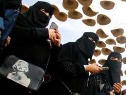 FILE - Saudi women attend a live music performance during a festival in Abha, southwest Saudi Arabia, Aug. 22, 2019.