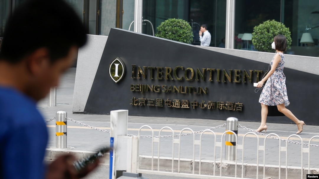 Seorang pria menggunakan ponsel di luar hotel InterContinental di distrik Sanlitun, di Beijing, China, 1 Agustus 2017. (Foto:dok)