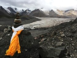 FILE - Scarves are tied to a rock cairn at the edge of a glacier valley in the holy Amnye Mache mountain range on the eastern edge of the Tibetan Plateau in northwestern China's Qinghai Province, Aug. 21, 2018.