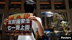 香港一名抗議者舉牌反對港版國安法，號召七一遊行。 （2020年6月30日）