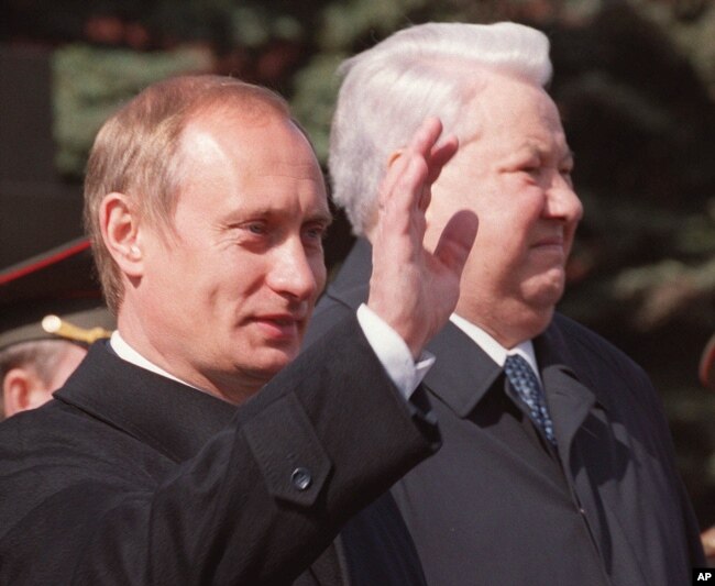 Presiden Rusia Vladimir Putin, kiri, melambai saat ia berdiri bersama mantan Presiden Boris Yeltsin dalam parade di Lapangan Merah, di Moskow, 9 Mei 2000. (Foto: AP)