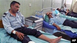 Iraqi policemen lie wounded at a hospital after a bomb blast in Hilla, south of Baghdad, May 5, 2011