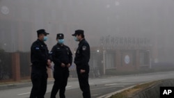 Security personnel stand guard near the Wuhan Institute of Virology after a World Health Organization team arrived for a field visit in Wuhan in China's Hubei province Wednesday, Feb. 3, 2021. The WHO team is investigating the origins of the…